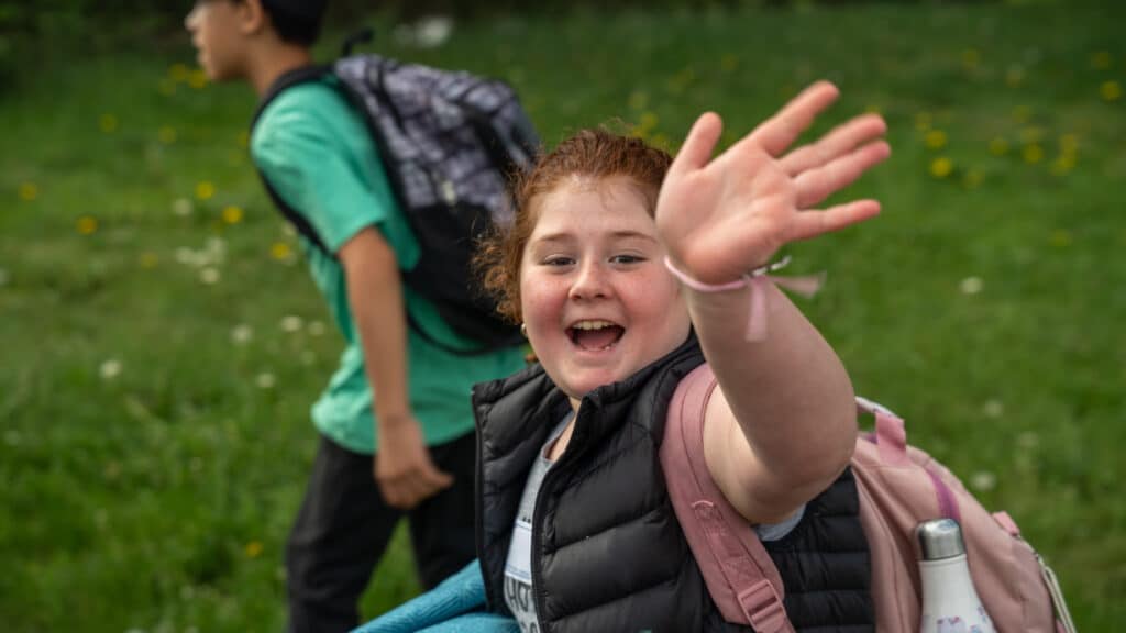 A young patroller excitedly waves as she enters the year end party.