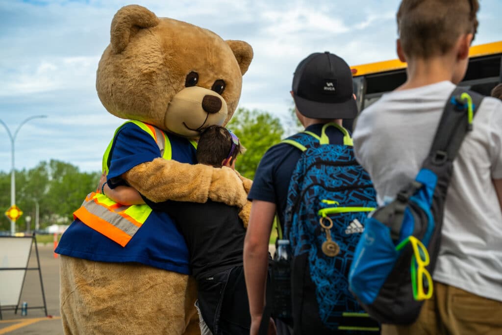 AMA's Teddy welcomes young patrollers with a warm bear hug.